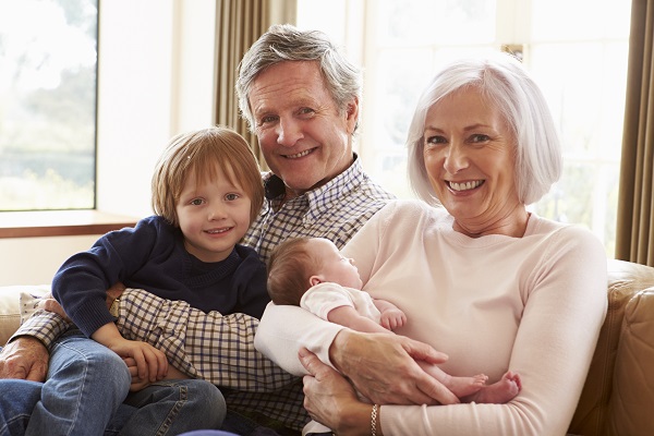 Grandparents With Grandson And Newborn Baby Granddaughter